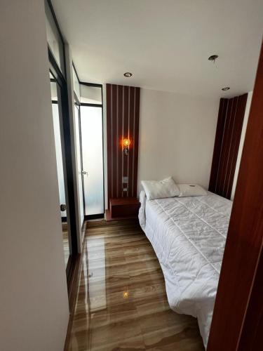 a bedroom with a white bed and a window at Hotel SOGU TOWER in Ayacucho