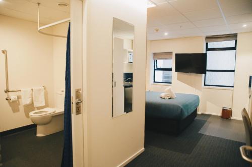 a hotel room with a bed and a toilet at Park Hotel, Lambton Quay in Wellington
