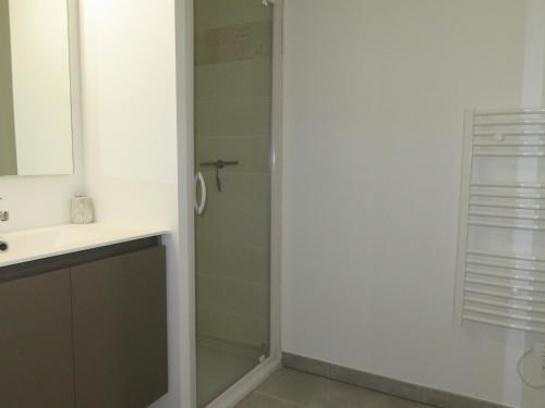 une salle de bain avec douche et lavabo dans l'établissement Élégant T3 avec terrasse, parking et proche plages à Sète - 3 étoiles - FR-1-338-381, à Sète