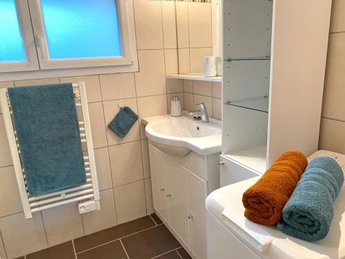 a bathroom with a sink and a toilet with towels at Gîte cosy avec spa, grand jardin, proche de la rivière Sioule - idéal pour famille et relaxation - FR-1-489-342 in Saint-Bonnet-de-Rochefort