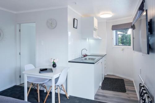 a small kitchen with a sink and a table at Dunrovin Motel in Taupo