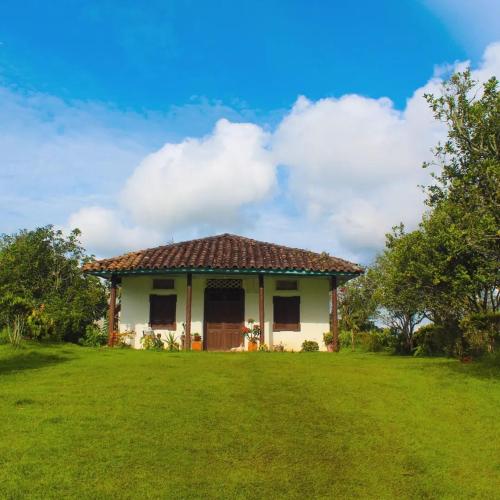 uma pequena casa com um jardim relvado em frente em Hotel Casa de Teja em Norcasia