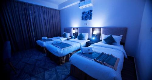 a room with two beds in a blue room at شاليهات وفلل ريلاكس بلاس in Sirr Āl Ghalīz̧