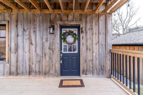 a wooden house with a blue door and a wreath at Elegant Elora Home with Stylish Décor in Elora