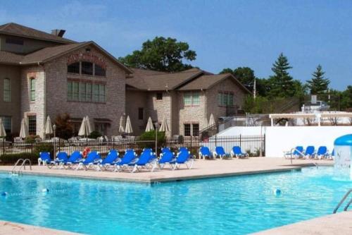 une piscine avec des chaises bleues et un bâtiment dans l'établissement Luxury Family Condo w/ Great Views & Entertainment, à Branson