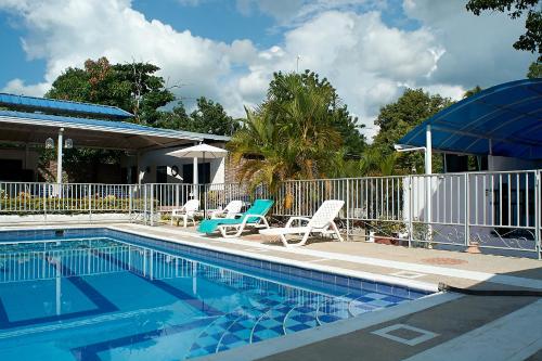 a swimming pool with two chairs and a fence at EL CIELO By Ruby in La Victoria