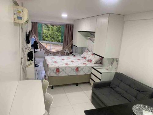 1 dormitorio pequeño con 1 cama y 1 sofá en Flat Beira Mar Carapibus, en Conde