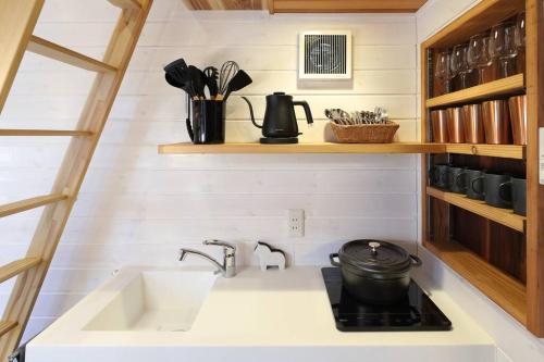 a kitchen with a sink and a stove at サウナ・ジャグジー・完全貸し切りという贅沢　大人の秘密基地　Tiny Cabin TATEGU#02 in Miyota