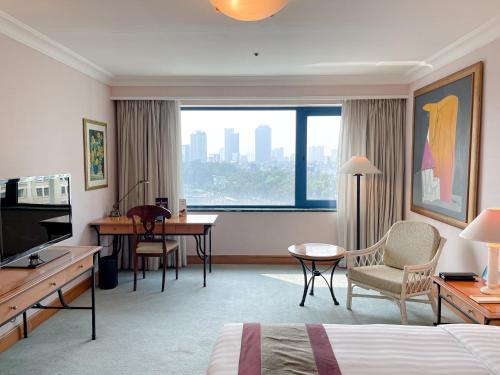 a hotel room with a bed and a desk at Hanoi Daewoo Hotel in Hanoi