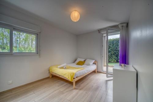 ein Schlafzimmer mit einem Bett mit gelber Bettwäsche und einem Fenster in der Unterkunft L'Echo - ST / Soitec / Innovalée in Saint-Ismier