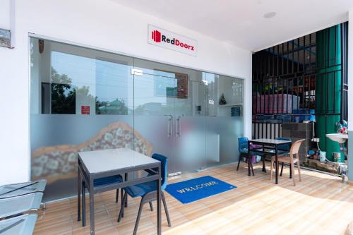 a restaurant with tables and chairs in a room at RedDoorz near Hang Nadim Batam Airport in Nongsa