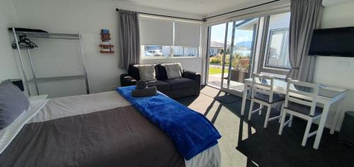 um quarto com uma cama, um sofá e uma mesa em Boujee em Lake Tekapo