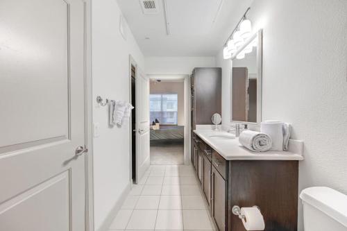 a white bathroom with a sink and a mirror at Beautiful 1Br/NRG/Pool/Wi-Fi/PetsOK/Garage parking in Houston