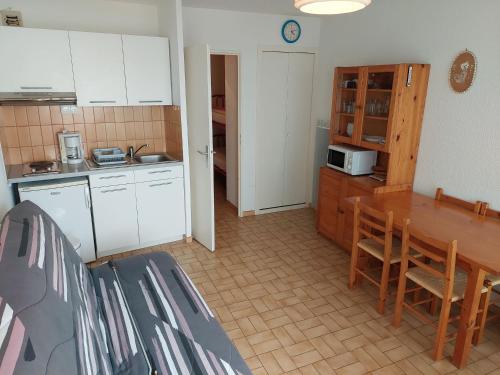 une cuisine avec des armoires blanches et une table et des chaises dans l'établissement Studio avec Terrasse et Parking Privé à La Grande Motte - 4 Pers. - FR-1-716-8, à La Grande Motte