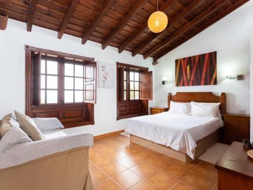 um quarto com uma cama e um sofá em Villa Icod de los Vinos, 1 dormitorio, 2 personas - ES-279-2 em Icod de los Vinos