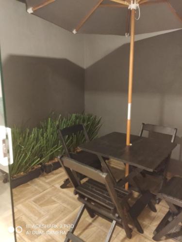 a black table and chairs with a plant at BORA BORA RESIDENCE in Joinville