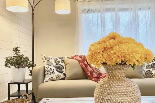 a vase filled with yellow flowers in a living room at Cozy and Quiet Family Home in Park Setting Near PDX in Vancouver