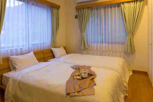 a bedroom with a large bed with a tray on it at スイートヴィラ 箱根強羅 in Gora
