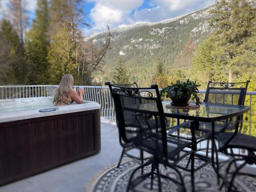 3BR, 2 bath w/ HOT TUB on private view balcony & AC في Crescent Valley: طاولة وكراسي على سطح مع حوض استحمام ساخن