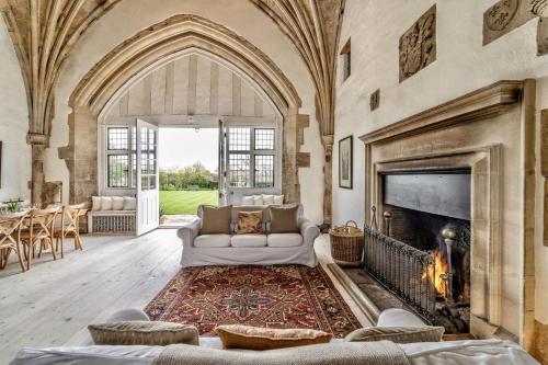 a living room with a fireplace and a couch at Butley Priory in Woodbridge