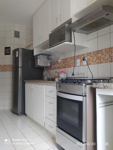 a kitchen with a stainless steel stove and refrigerator at Privê das Thermas 01 - Ar Split nos 2 quartos, ventilador na sala, purificador Soft gelada natural in Caldas Novas