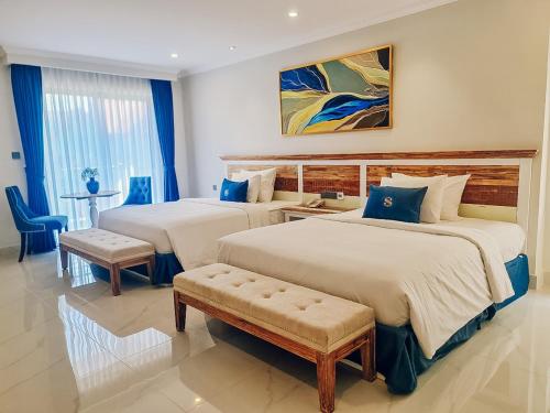 a hotel room with two beds and a table at Sabina Luxury Boutique Hotel & Villa in Vung Tau
