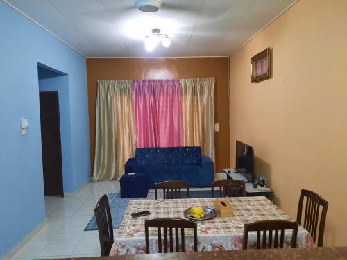 een woonkamer met een tafel en een blauwe bank bij Homestay cikgu in Kamunting