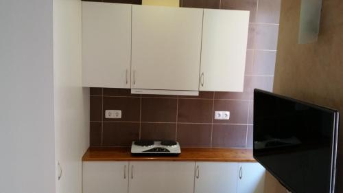 a kitchen with white cabinets and a television on a counter at Rossio Studios in Lisbon