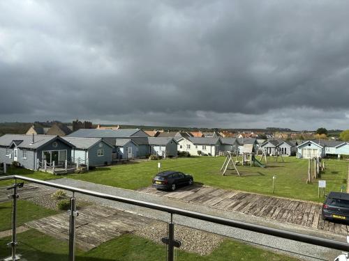 a car parked in a parking lot next to houses at Echo Beach - Sleeps 12 - Part of the The Bay Filey Holiday Village with pool, gym and direct beach access, pub, restaurant, tennis and meadows walks in Filey
