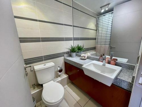 a bathroom with a toilet and a sink at Departamento con espectacular Ubicación, Vista al Mar y Panorámica a todo Iquique in Iquique