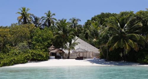a resort on a beach with palm trees and water at Nika Island Resort & Spa, Maldives in Nika Island