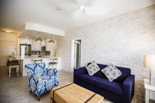 a living room with a blue couch and a kitchen at Ports of Call Resort in Grace Bay
