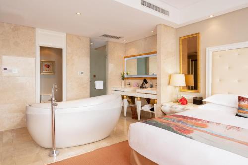 a bedroom with a tub and a bed and a sink at Hangzhou Xinqiao Hotel in Hangzhou