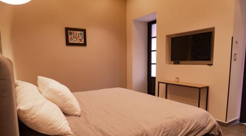 a bedroom with a bed and a flat screen tv at Hotel Capitalino in Pachuca de Soto