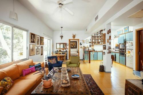a living room with a couch and a table at Frishman beach 2Br full of art and light in Tel Aviv