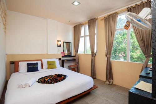 a bedroom with a large bed with a large window at Urbanview Hotel Ananda Syariah by RedDoorz in Bukittinggi