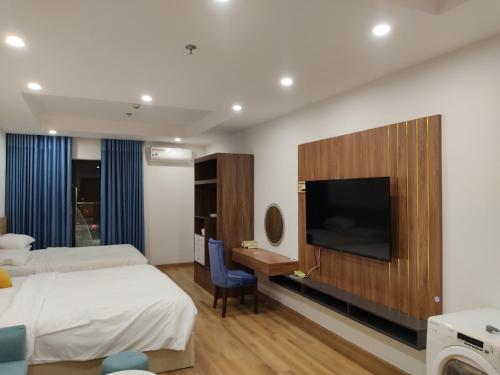 Habitación de hotel con 2 camas, escritorio y TV. en TMS Beachfront Quy Nhon - Holiday Apartment, en Quy Nhon