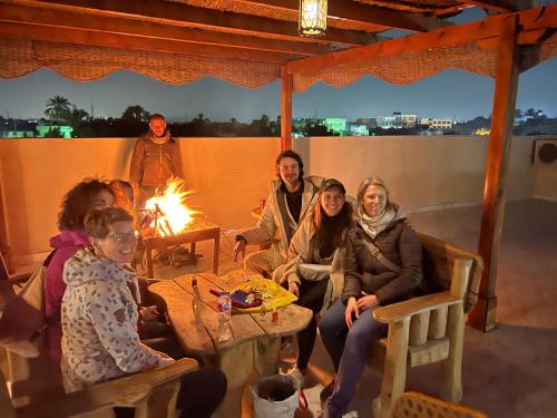 un grupo de personas sentadas alrededor de un fuego en Sunset Guesthouse Abusir en El Cairo