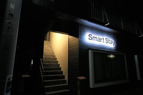 a sign for a smart shop with stairs in the dark at Smart Stay Ito 201 in Ito