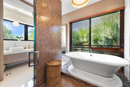 een badkamer met een bad en een douche met een raam bij Villa Bali in Miami