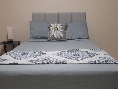 a bed with a flower pillow on top of it at Ultimate Chill Brown's Town in Browns Town