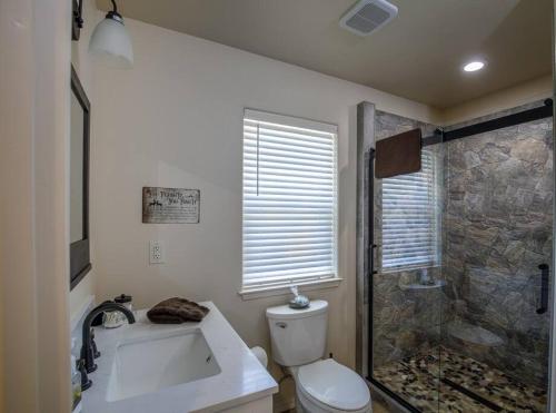 a bathroom with a shower and a toilet and a sink at Cozy Cub Cabin, brand new home near Yosemite in Mariposa