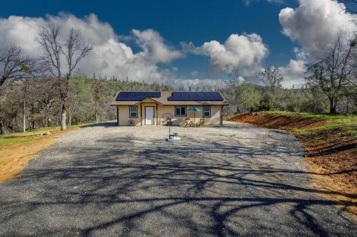 a house with a solar roof on a road at Cozy Cub Cabin, brand new home near Yosemite in Mariposa