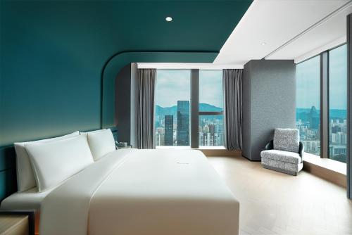 a bedroom with a large white bed and a large window at Atour S Hotel Lanzhou Convertion Exhibition Center in Lanzhou