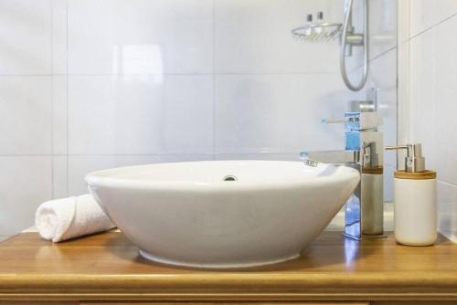 a white sink on a wooden counter in a bathroom at 'Troppo' Darwin Designer Luxury Boutique Home in Paraparap