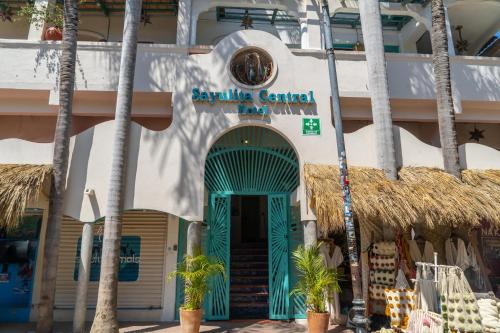 a building with a blue door and palm trees at Sayulita Central Hotel in Sayulita
