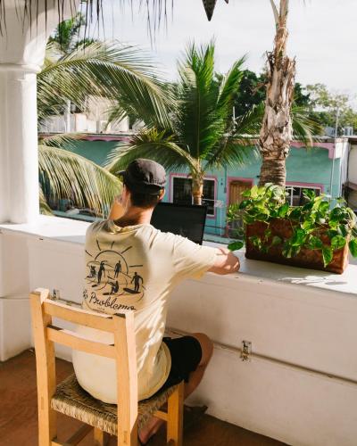 a man sitting in a chair in front of a computer at Sayulita Central Hotel in Sayulita