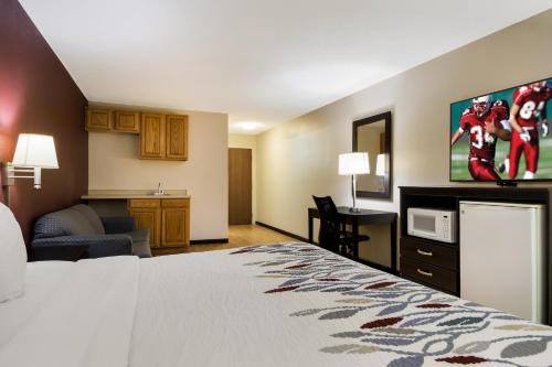 a hotel room with a bed and a kitchen at Red Roof Inn South Bend - Mishawaka in South Bend