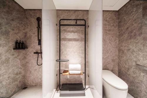 a bathroom with a shower and a toilet at Urcove by HYATT Shanghai Wujiaochang in Shanghai
