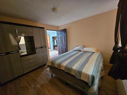 1 dormitorio con 1 cama y vestidor en La casa de mama rosita, comoda y acogedora, en Quetzaltenango